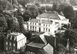  The photo shows the company's building around 1925, surrounded by lush trees that conceal the course of the river Aa. 