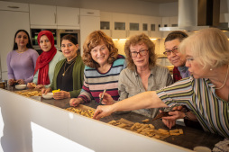  Young people and senior citizens bake Christmas biscuits together 